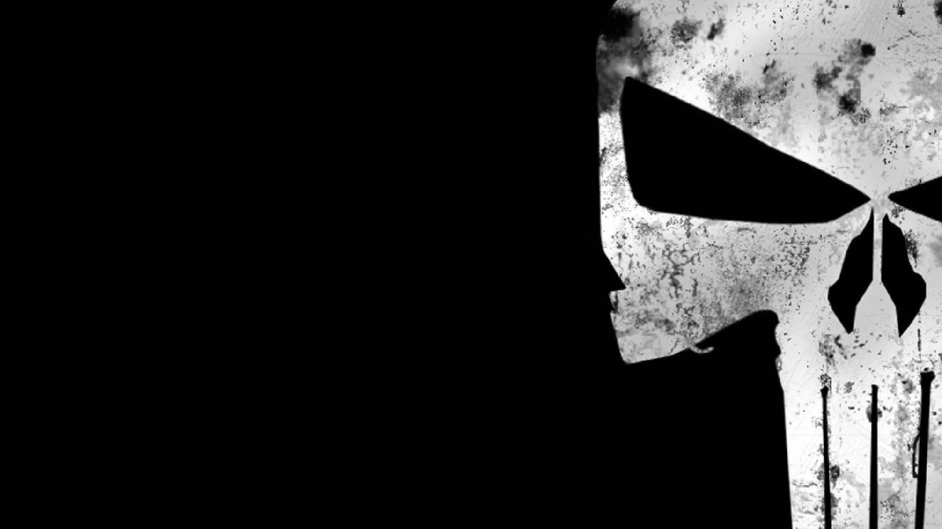 半骷髏Punisher標誌 壁紙 — 一個粗糙的白色骷髏頭，帶有黑色眼窩和牙齒，在純黑色背景上顯得格外突出。