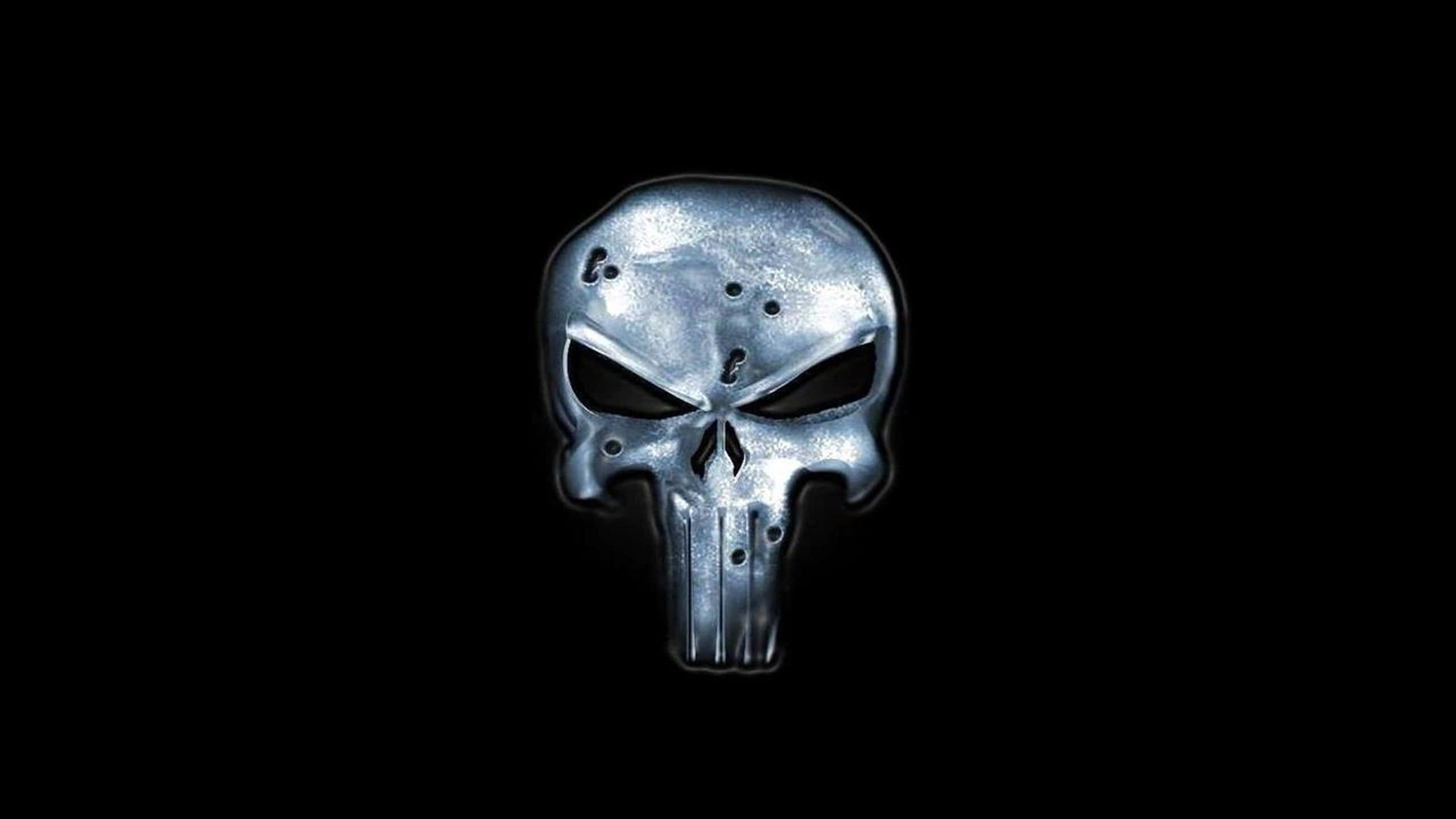 Punisher 標誌桌面背景 壁紙 — 一個帶有彈孔的金屬骷髏標誌在純黑色背景上發光。