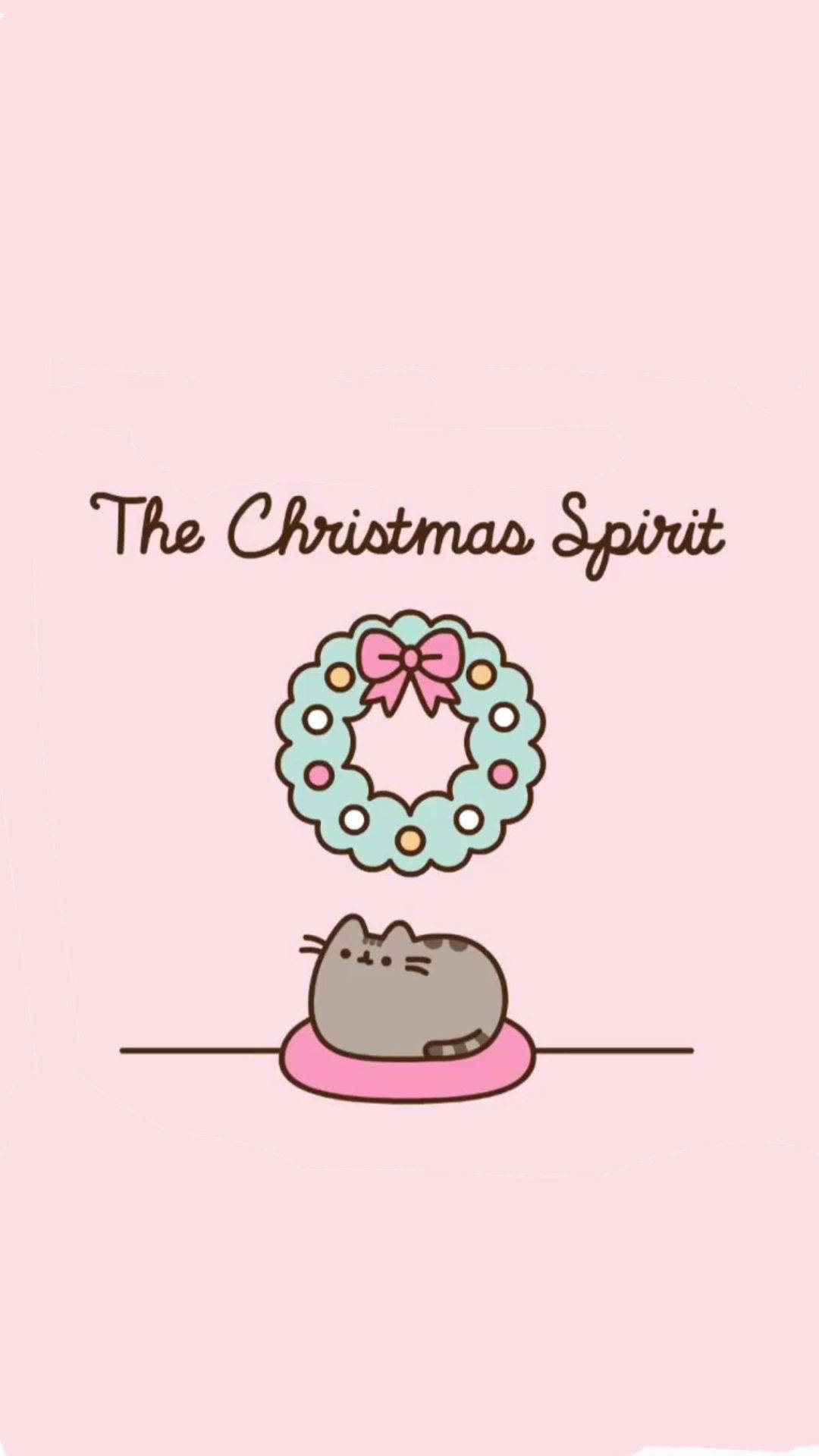 Pusheen 可愛聖誕節 壁紙 — 一隻可愛的灰色貓咪坐在粉紅色墊子上，下方是帶有粉紅色蝴蝶結的節日花環，背景是柔和的粉紅色。