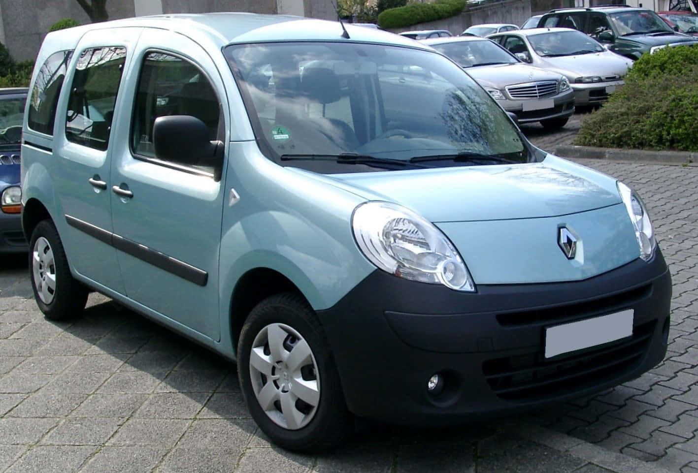 Renault Kangoo 桌布 壁紙 — 一輛淺藍色雷諾Kangoo客貨車停泊在鋪砌的停車場上，背景有其他車輛。