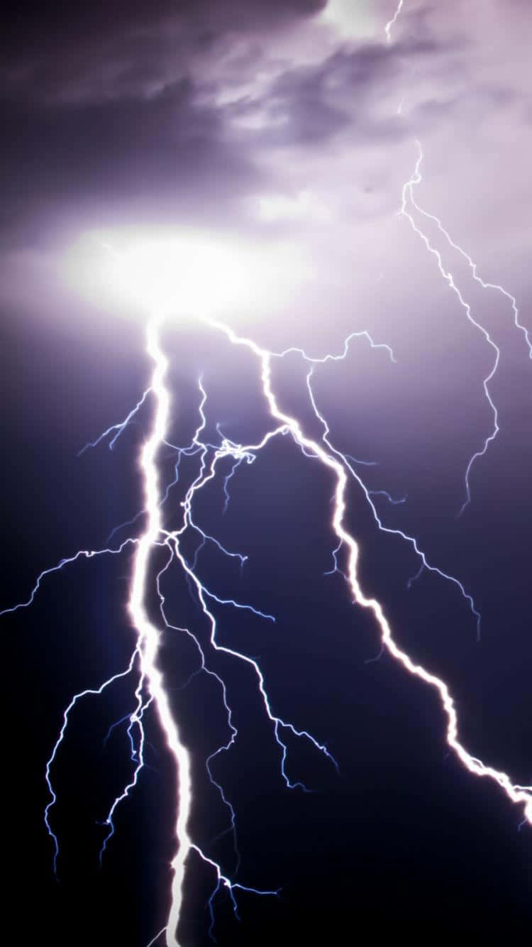 Lightning iPhone 桌布 壁紙 — 一道強大的閃電在黑暗的暴風雨天空中分叉，用電光白和藍色能量照亮紫色雲層。