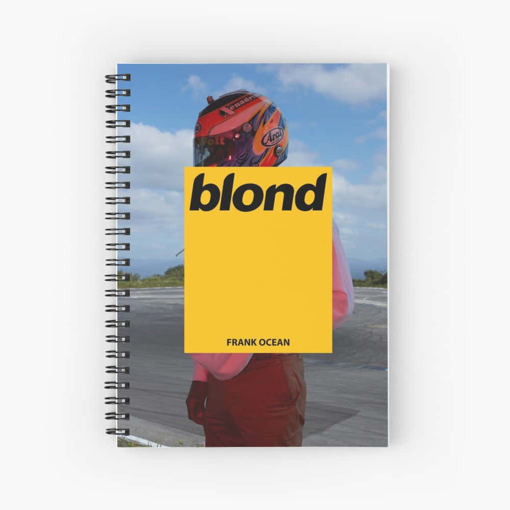 R&B天王Frank Ocean，未來可期 壁紙 — 螺旋筆記本封面，上面有一個人戴著色彩繽紛的賽車頭盔，一個大膽的黃色區塊顯示「blond」字樣，下方是「FRANK OCEAN」。