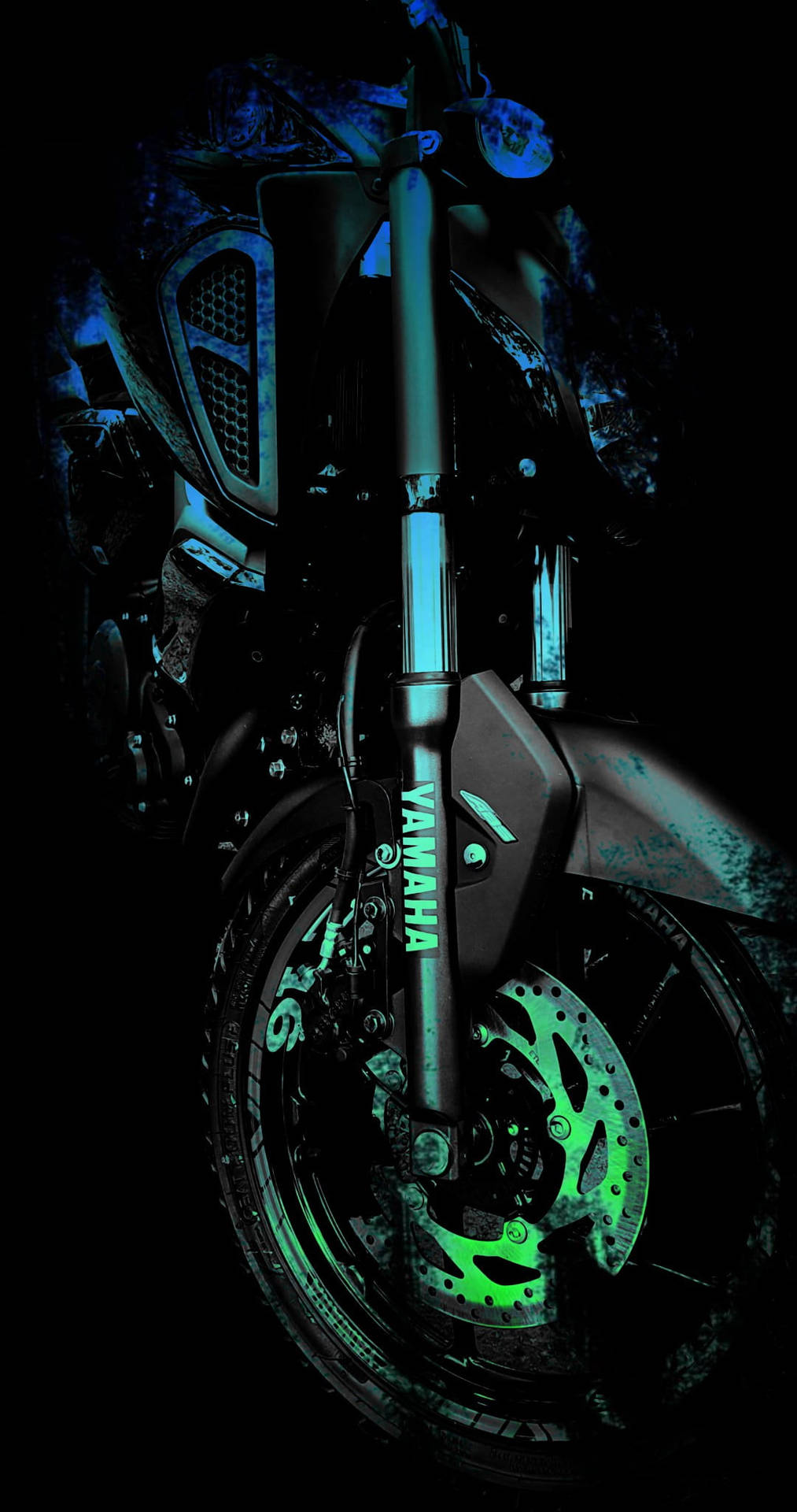 黑暗中發出螢光綠色和藍色光芒的 Yamaha 電單車前端。