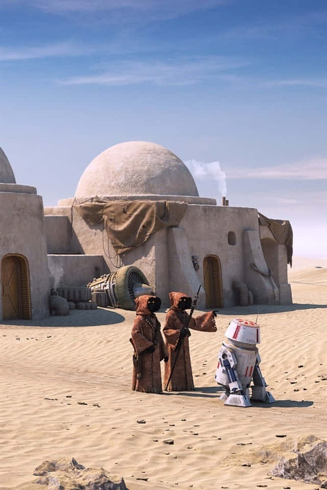 賈瓦人與R2-D2塔圖因背景 壁紙 — 兩名身穿棕色長袍的沙漠居民站在一個白色機械人旁邊，面前是一座圓頂砂岩住所，背景是清澈的藍天。