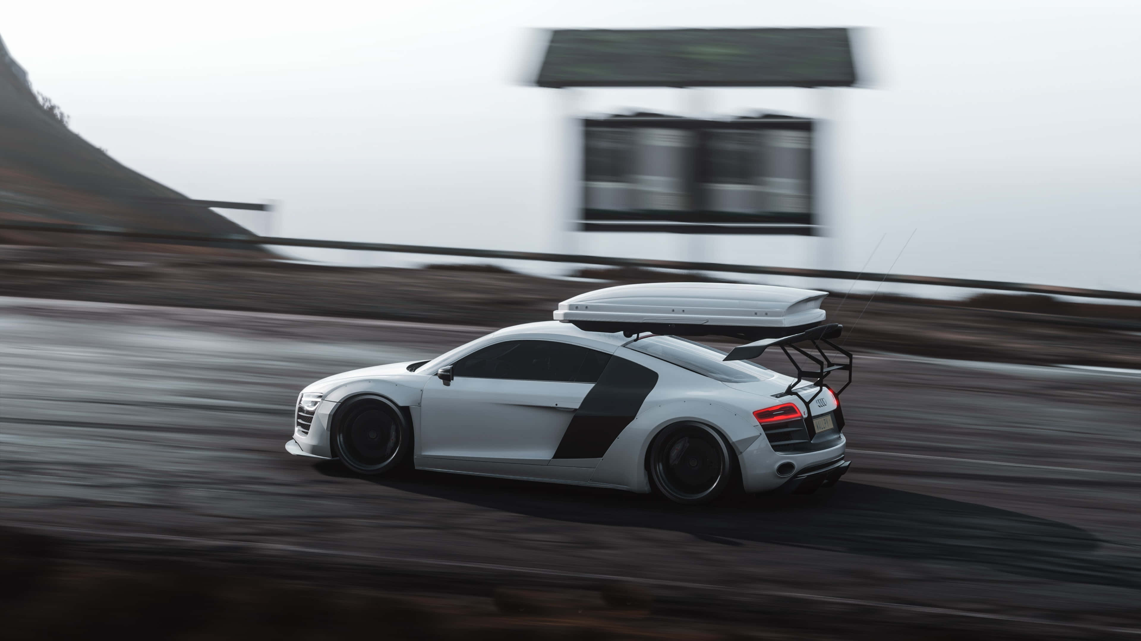 奧迪R8 Forza Horizon 4 高清 壁紙 — 一輛白色奧迪R8跑車裝著車頂行李箱，在濕滑的道路上奔馳，背景是模糊的山丘。