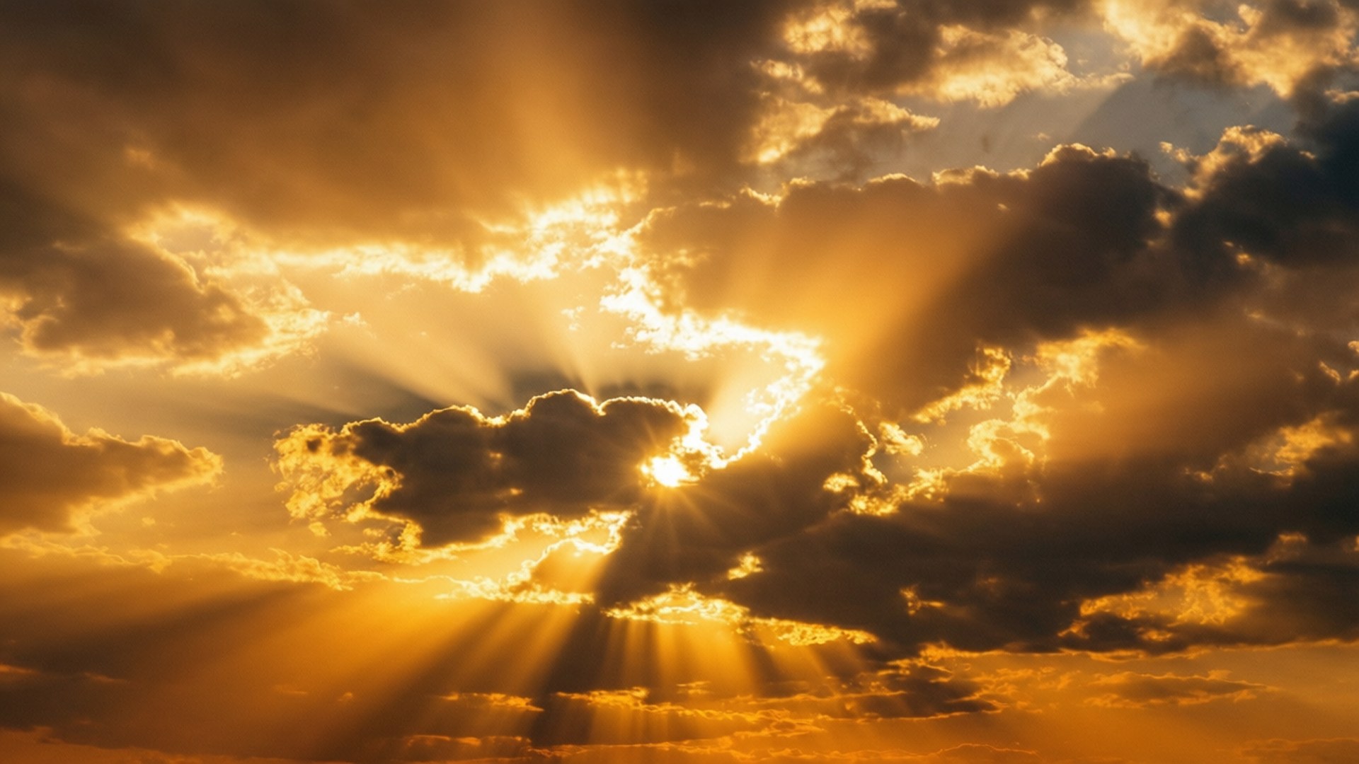 在充滿活力的日落期間，陽光穿過烏雲照耀。