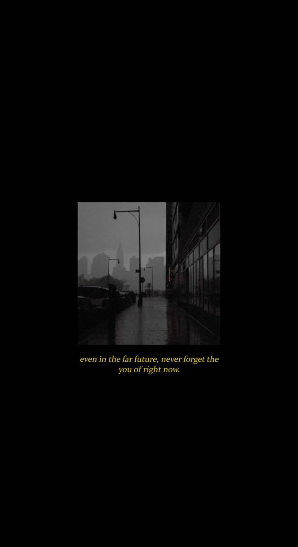  壁紙 — 黃昏時分的雨後城市街道，模糊的城市天際線和濕漉漉的人行道反射著昏暗的燈光。