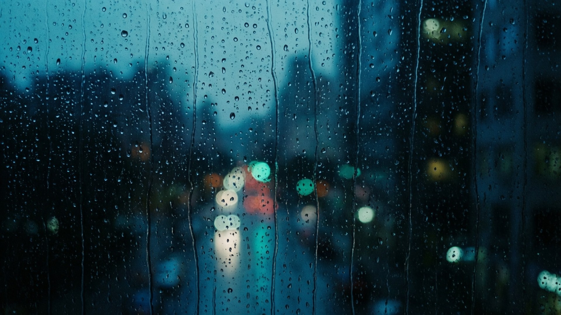 窗戶上的雨滴與夜晚模糊的城市燈光