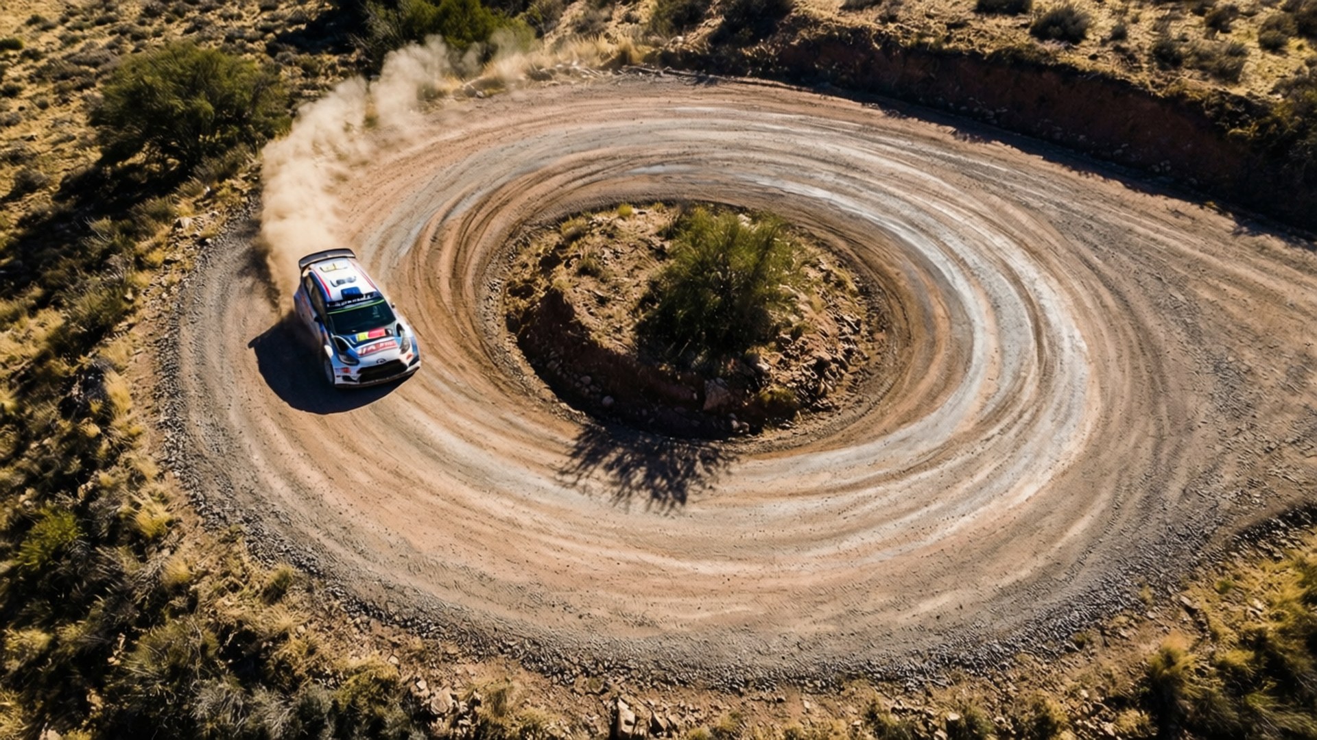 Hairpin Dust 壁紙 — 一輛拉力賽車在崎嶇的沙漠泥路上高速駛過一個緊密的螺旋彎，揚起塵土。
