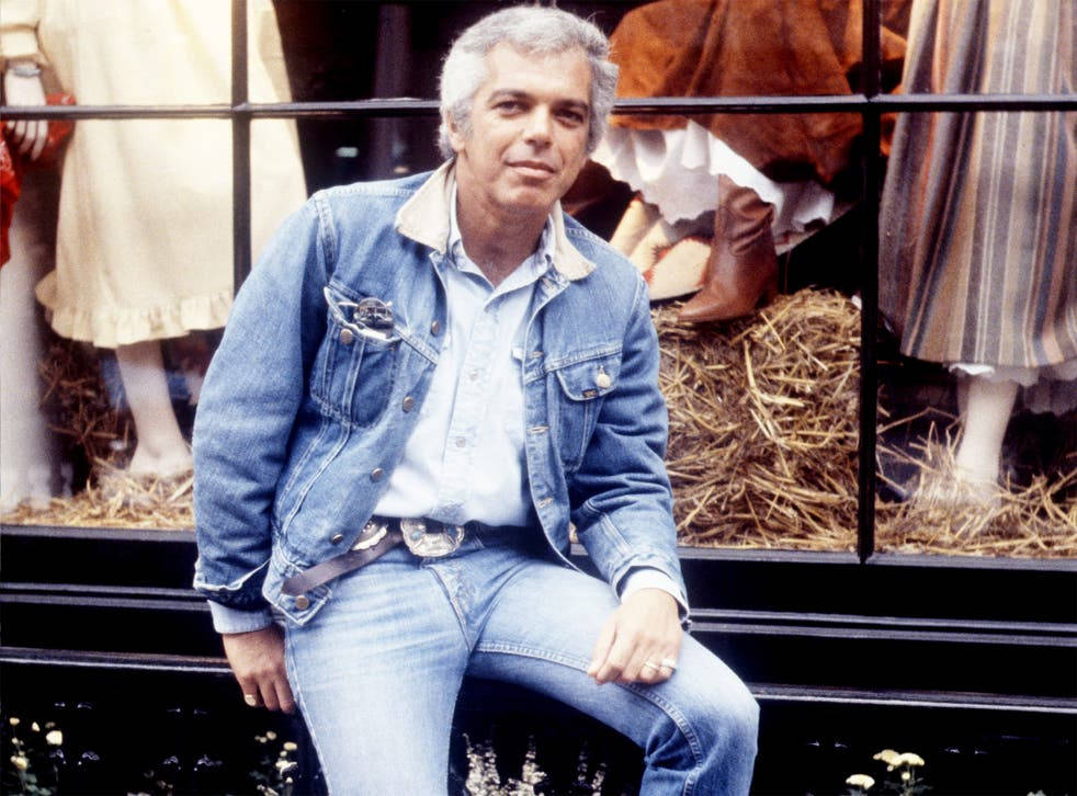 Ralph Lauren 全牛仔造型 壁紙 — 一名身穿牛仔外套和牛仔褲的男子隨意地坐在商店櫥窗前，櫥窗內有穿著復古連衣裙的人體模型放在乾草上。