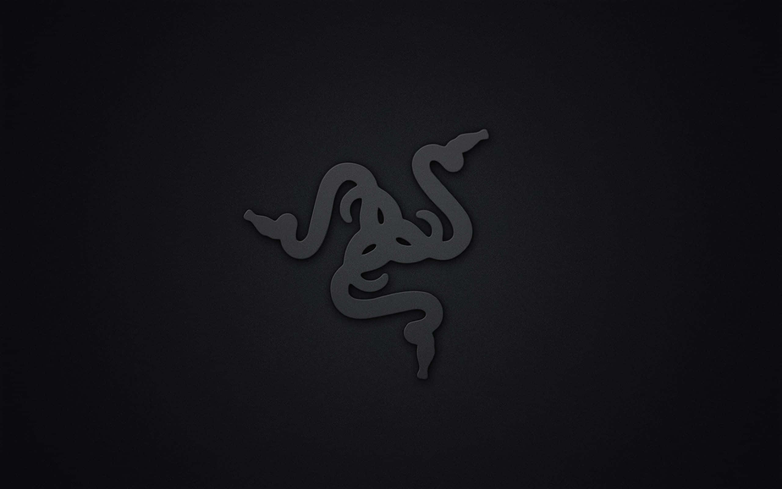 用 Razer 玩遊戲 壁紙 — 一個時尚的深灰色 Razer 標誌，帶有微妙的燈光，居中放置在帶紋理的黑色背景上。