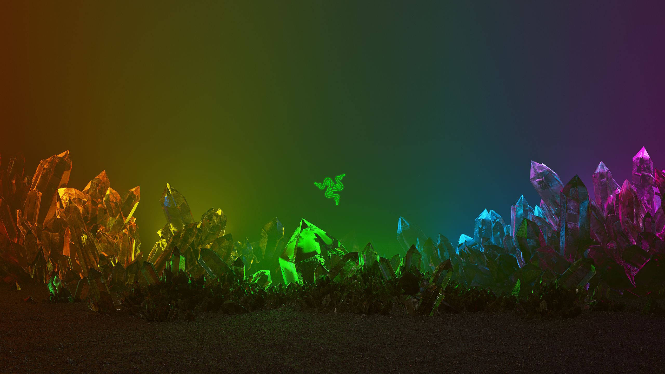 Razer 水晶 Chroma 壁紙 — 發光的彩虹水晶從黑暗的地面升起，在漸變的天空下，上方漂浮著綠色的 Razer 標誌。
