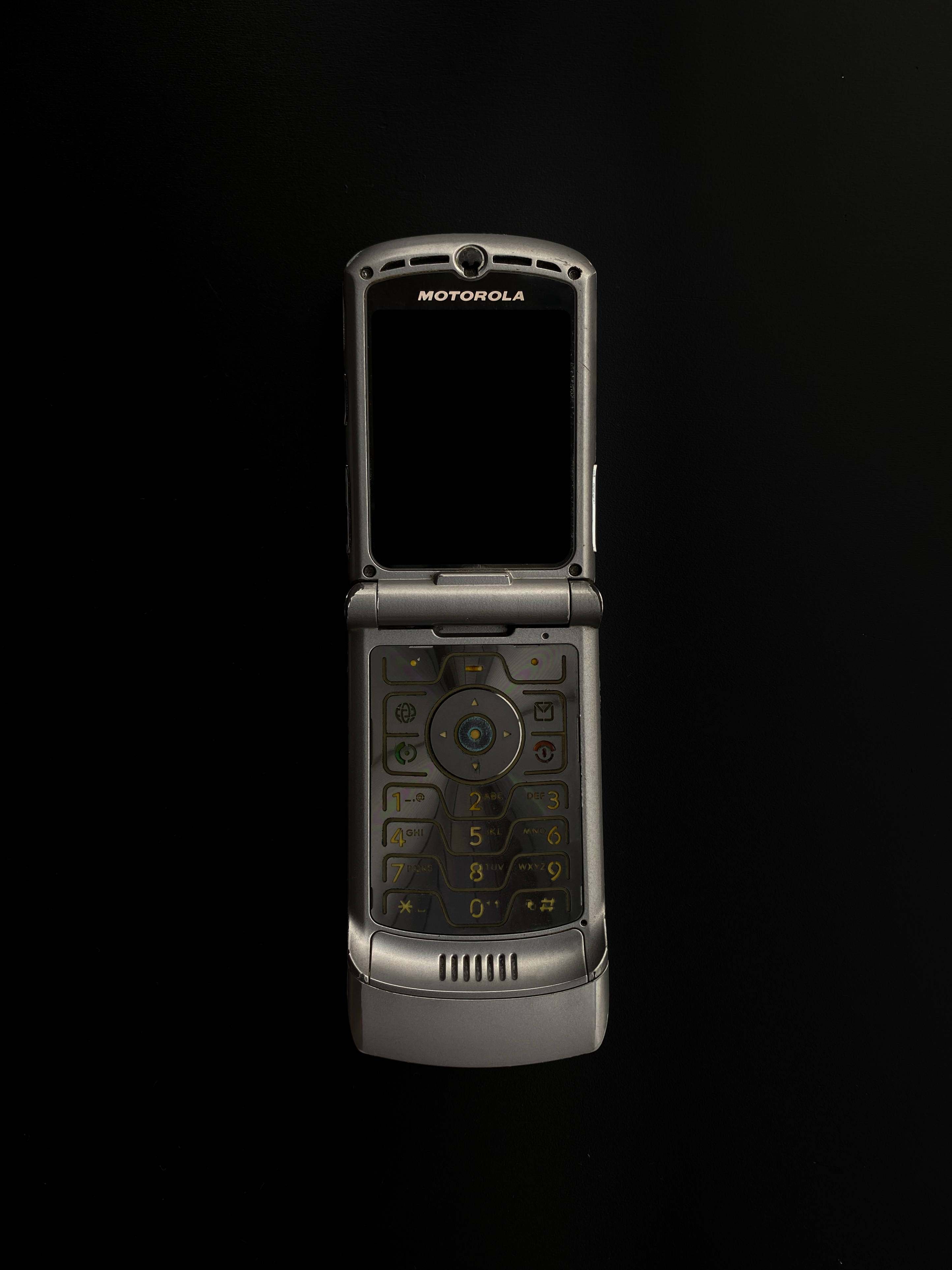 銀色摩托羅拉 Razr 壁紙 — 一部銀色 Motorola 摺機打開，在純黑背景上突顯其鍵盤和屏幕。