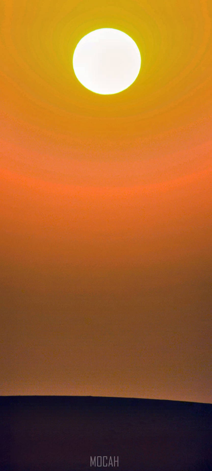 一顆發光的太陽在黑暗的地平線上下沉，伴隨著充滿活力的橙色和靛藍色天空。