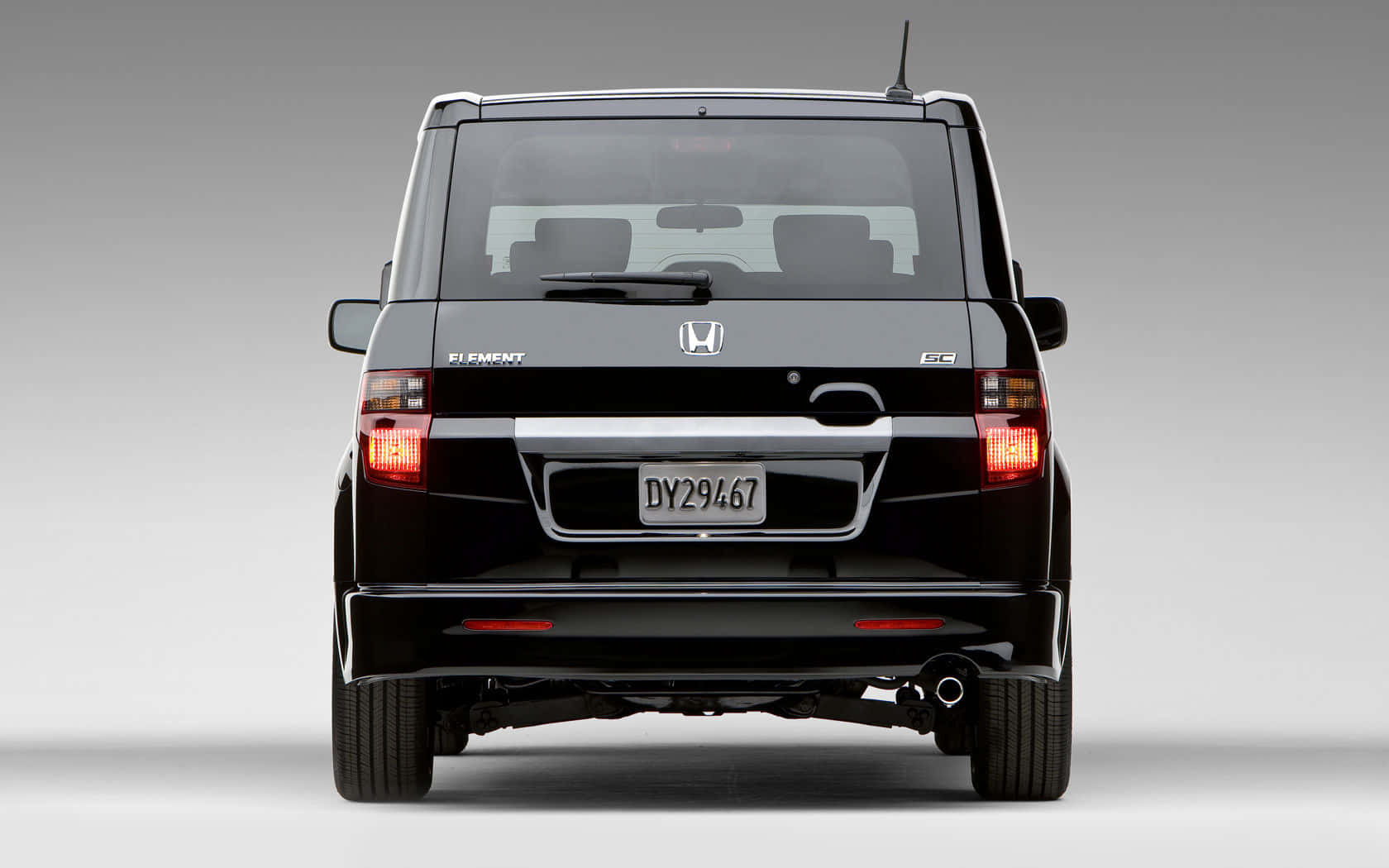 Honda Element 桌布 壁紙 — 黑色本田Element SUV後視圖，配紅色尾燈和銀色飾條，背景為中性灰色工作室背景。
