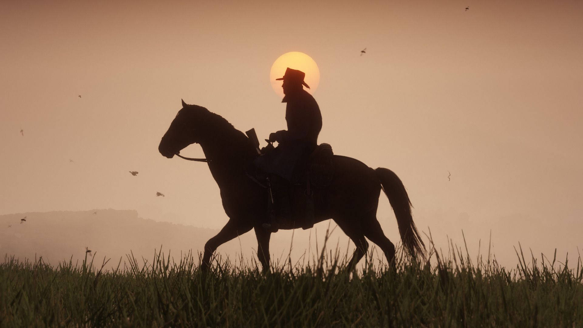 《Red Dead Redemption 2》騎馬牛仔日落 壁紙 — 一個孤獨的牛仔騎著馬穿過日落時分的草地，太陽在他身後發光。