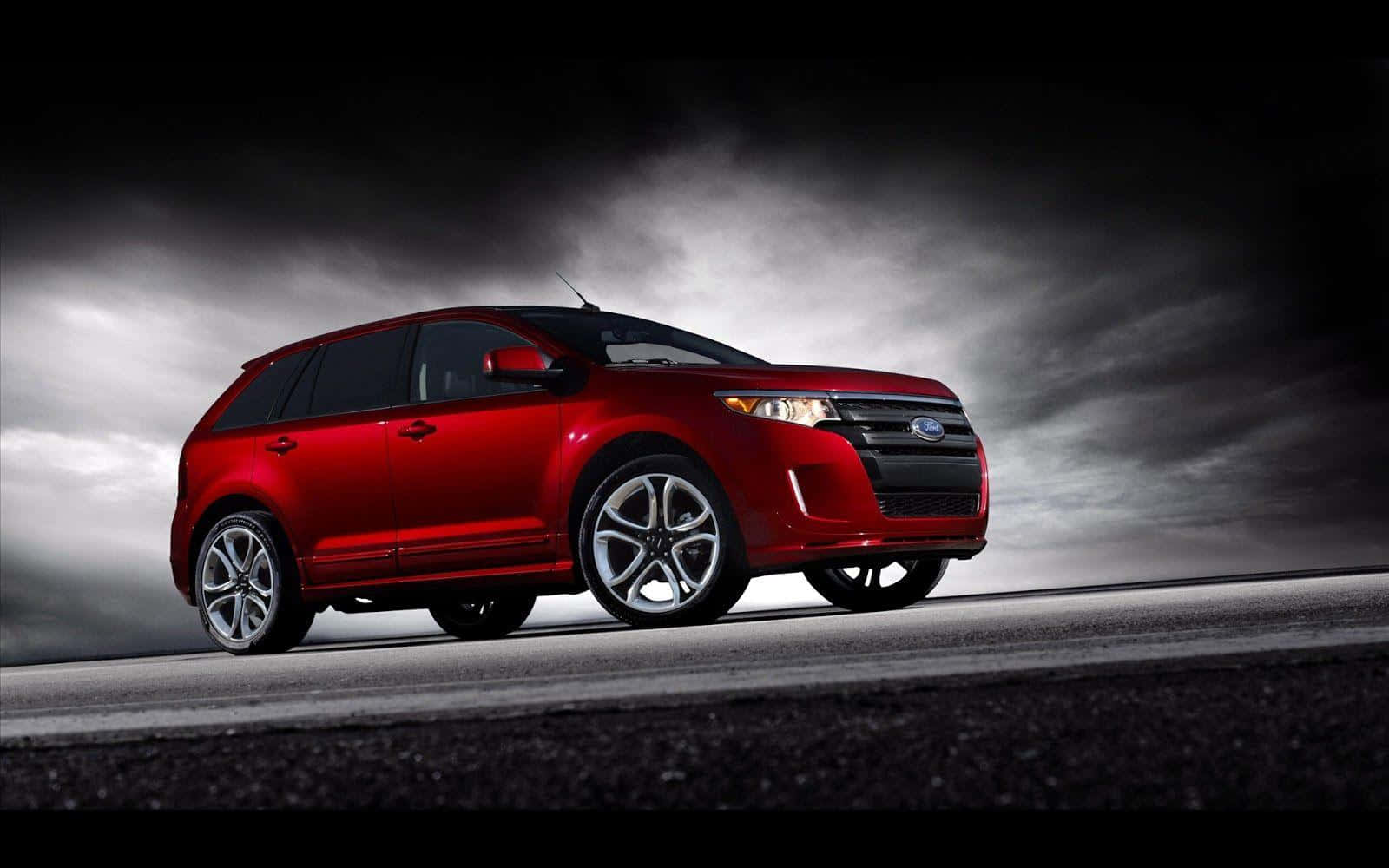 Ford Edge 桌布 壁紙 — 一輛亮紅色的福特Edge SUV停在濕滑的道路上，背景是烏雲密佈的暴風雨天空。