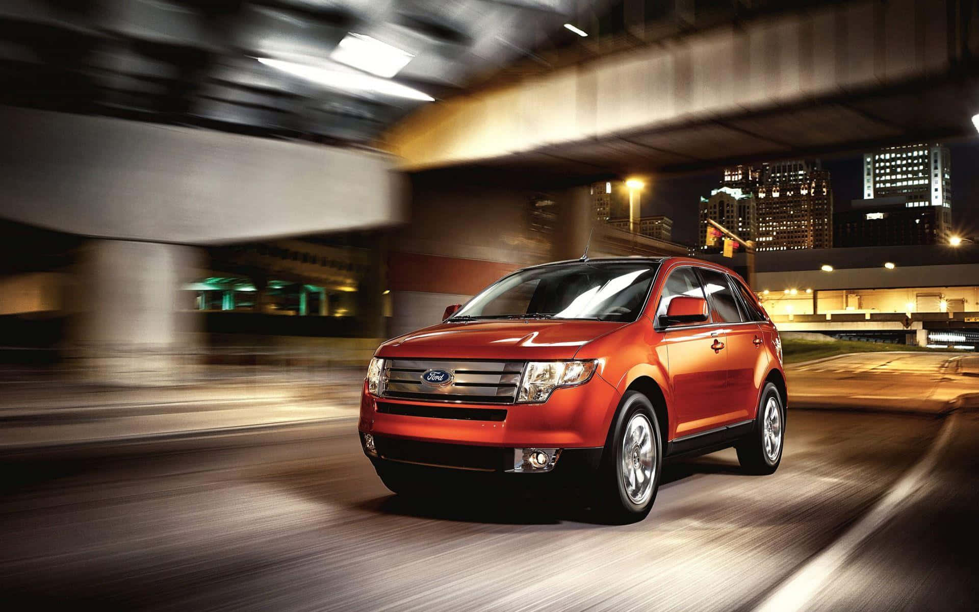 Ford Edge 桌布 壁紙 — 一輛鮮紅色的福特Edge SUV在夜間穿過模糊的城市隧道，背景是閃爍的城市燈光。