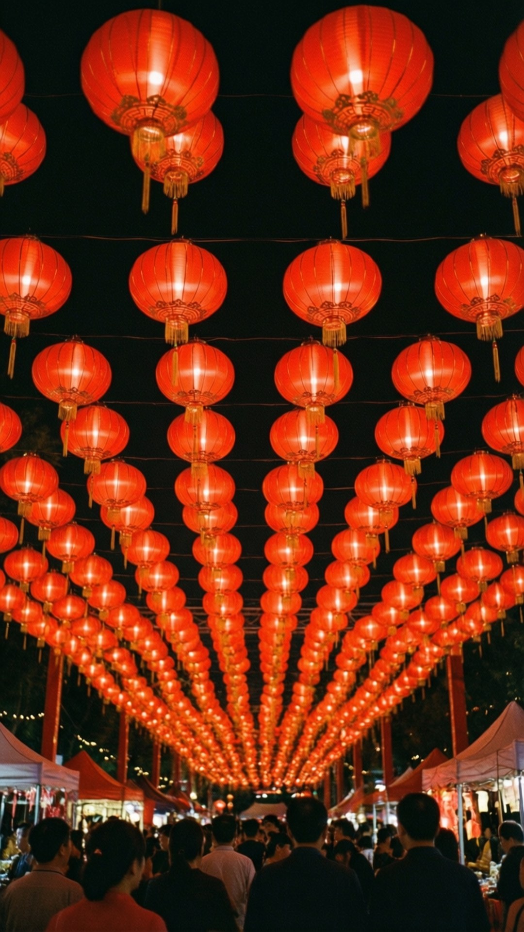 一排排發光的紅色燈籠懸掛在擁擠的夜市上方。