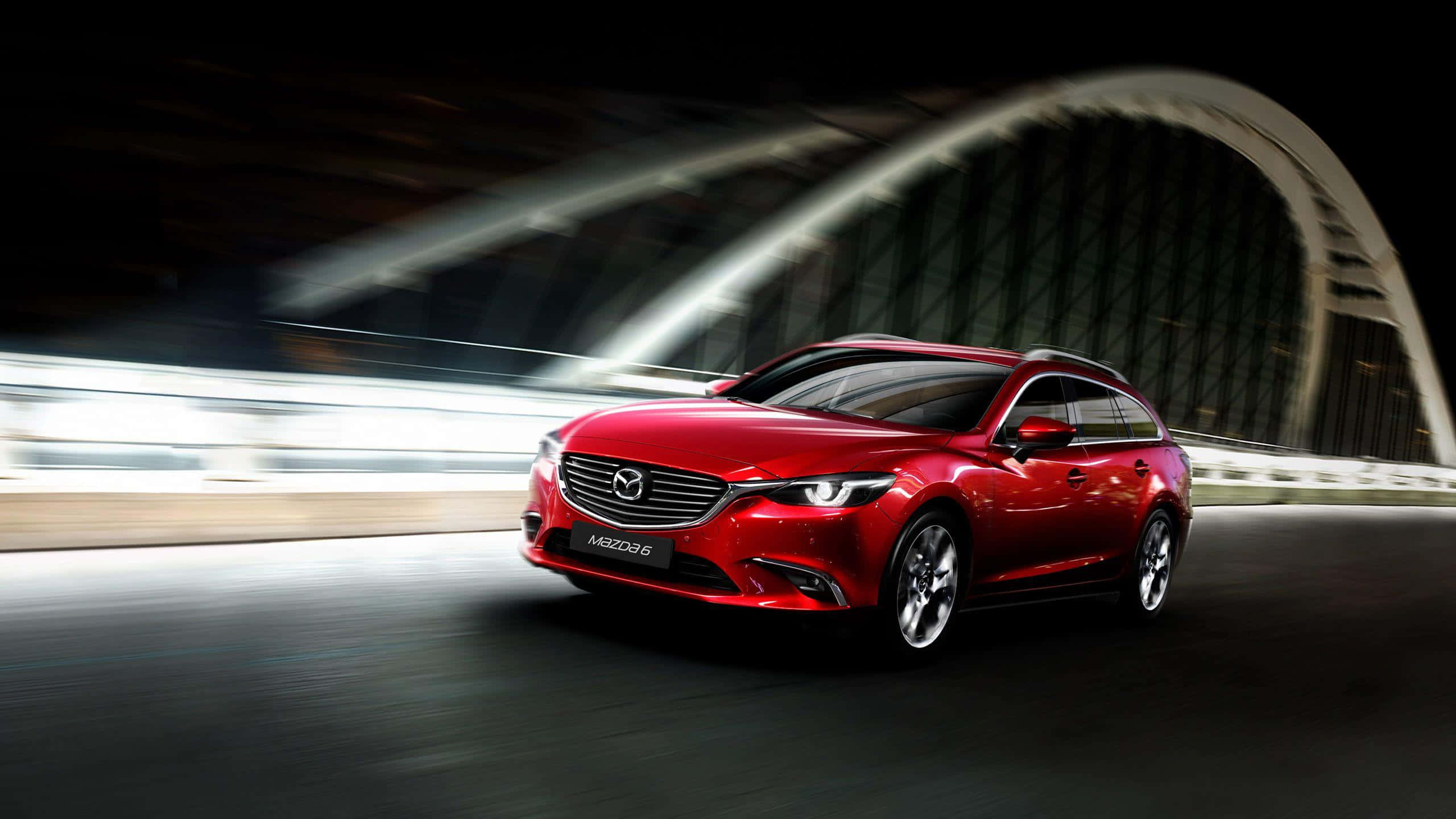 Mazda 6 桌布 壁紙 — 一輛鮮紅色的萬事得6旅行車在夜間於發光的拱橋下高速行駛，帶有動態模糊條紋。