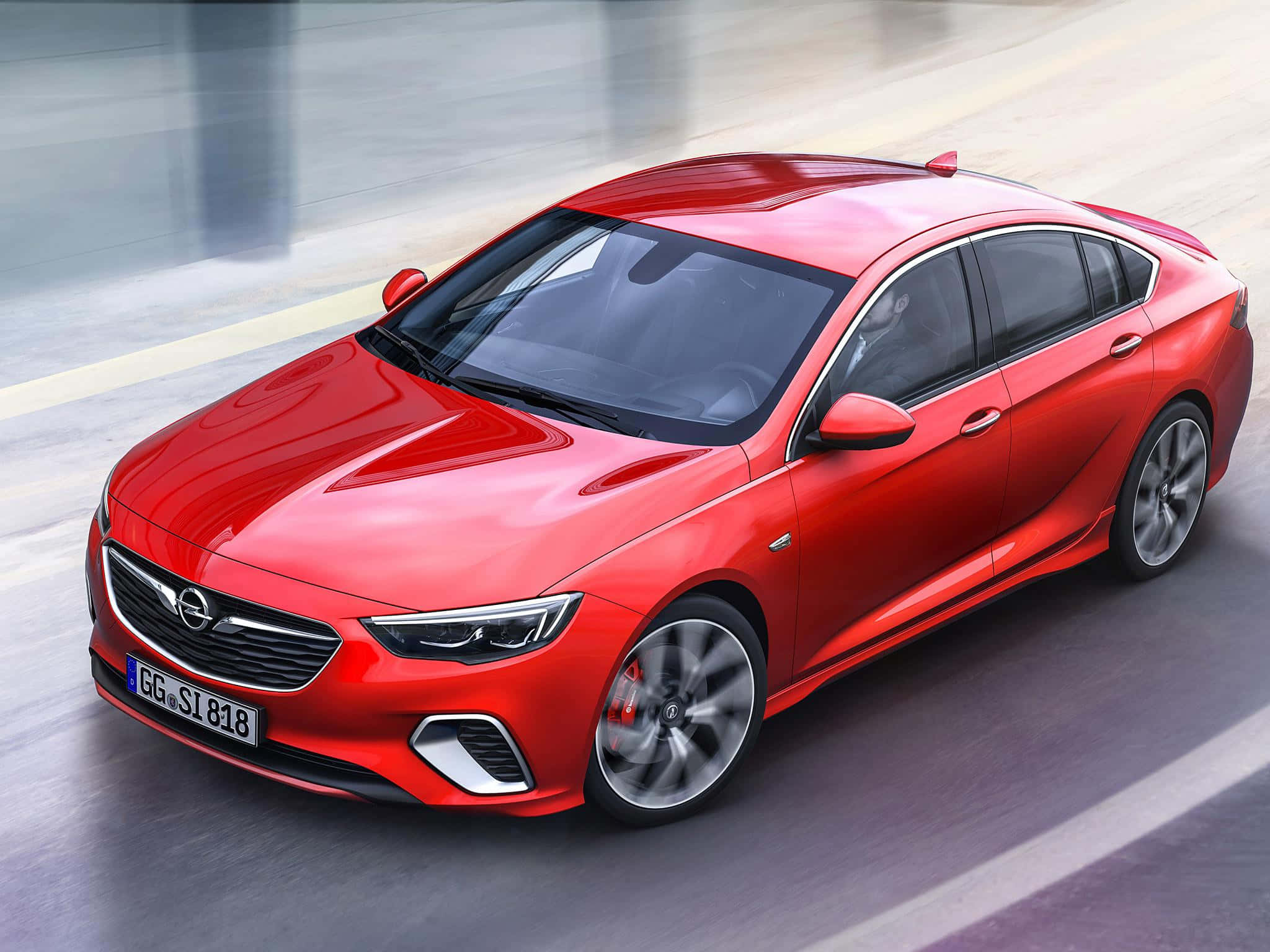 Opel Insignia 桌布 壁紙 — 一輛鮮紅色的歐寶Insignia在模糊的城市道路上飛馳，動態模糊強調其流線型空氣動力學設計。