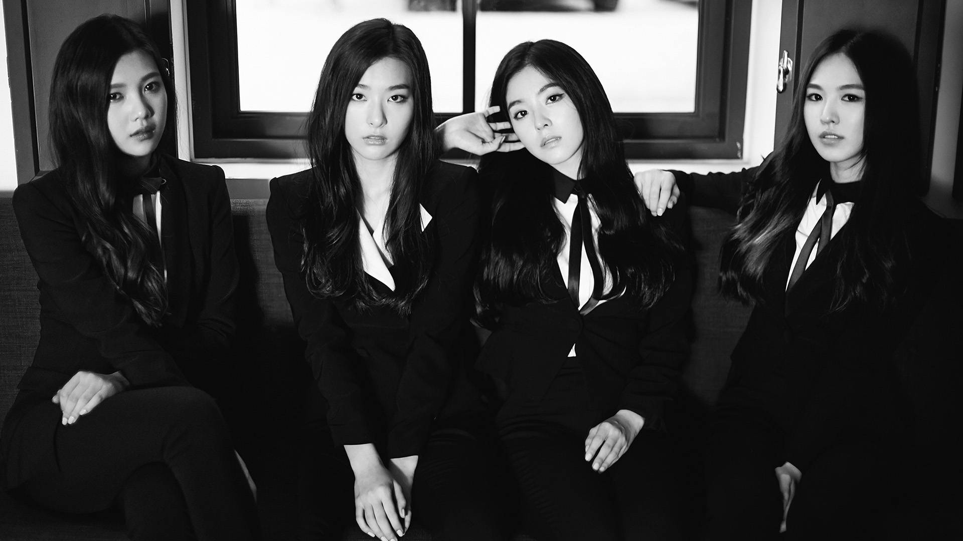 Red Velvet 女子團體 Sheesh 黑色造型 壁紙 — 四位身穿黑色西裝的女性坐在梳化上，表情嚴肅，呈現出鮮明的黑白肖像。