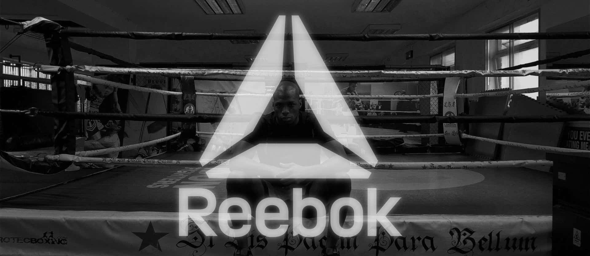 動起來，賦能自己 — Reebok 壁紙 — 一名拳擊手坐在燈光昏暗的擂台上，發光的Reebok標誌以單色疊加在場景上。