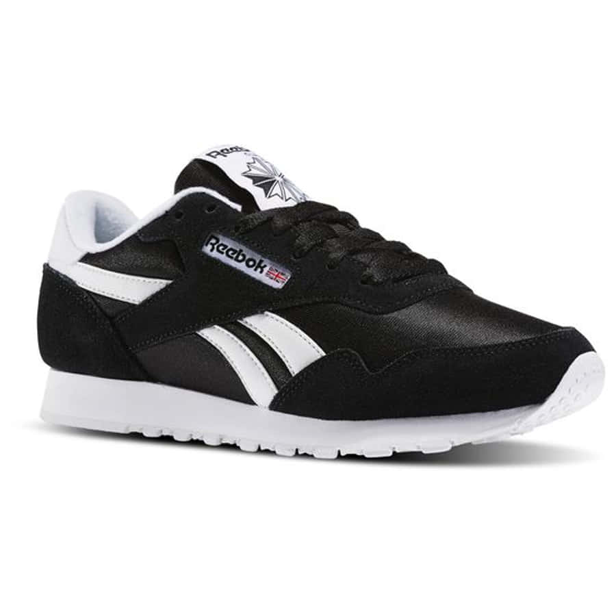 穿上Reebok鞋款，把你的運動表現提升到新高度！ 壁紙 — 經典黑白 Reebok 運動鞋，帶有標誌性條紋和標誌，在乾淨的攝影棚燈光下展示。
