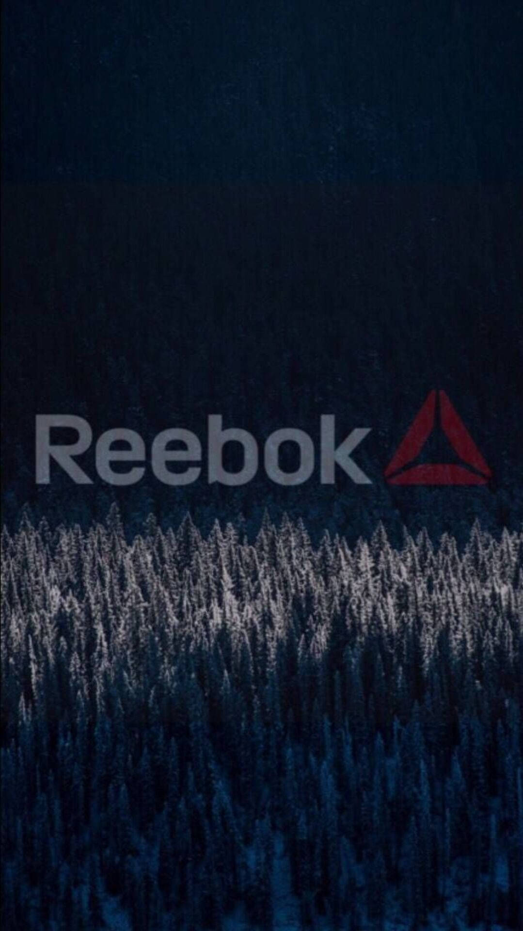 Reebok 標誌在黑暗冬季森林的雪松樹上方。