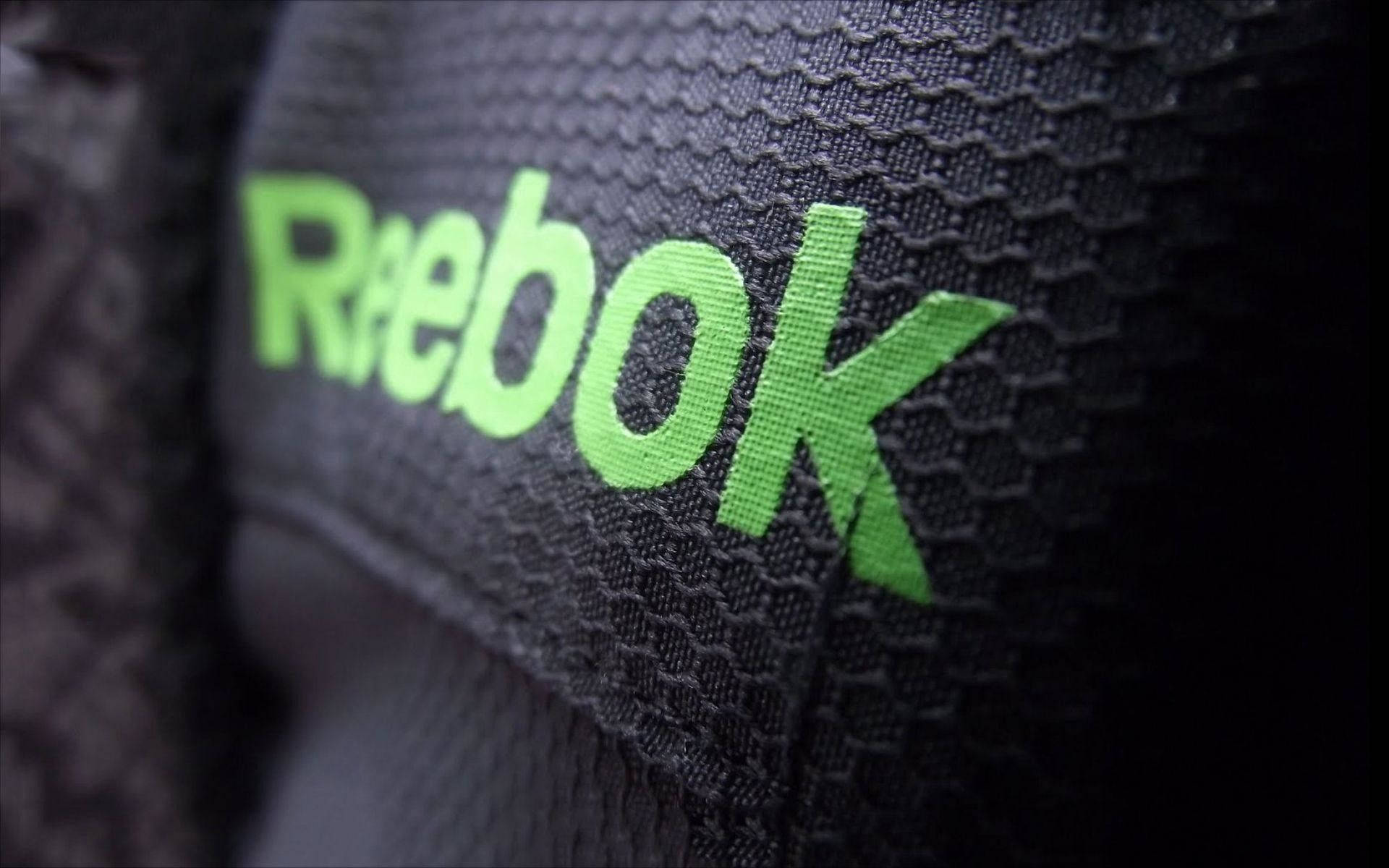 近距離拍攝黑色運動布料上的Reebok標誌。