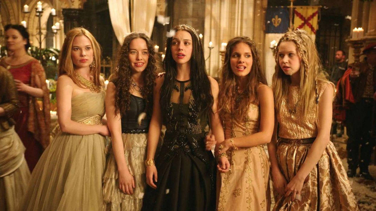 《Reign》：皇家優雅的傳奇 壁紙 — 五位身穿華麗中世紀長袍的女性，在燭光映照的城堡大廳中，與旗幟和石造建築一同站立。