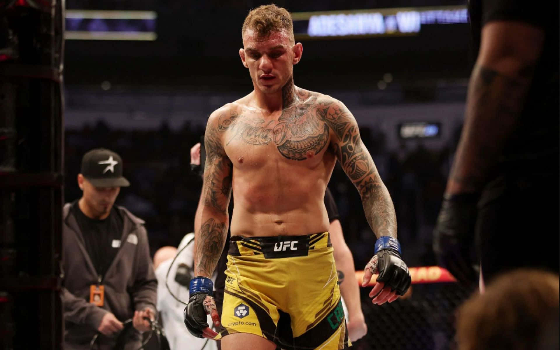 Renato Moicano 站在擂台內 壁紙 — 一位紋身的MMA拳手穿著黃色UFC短褲，在場館燈光下走出八角籠。