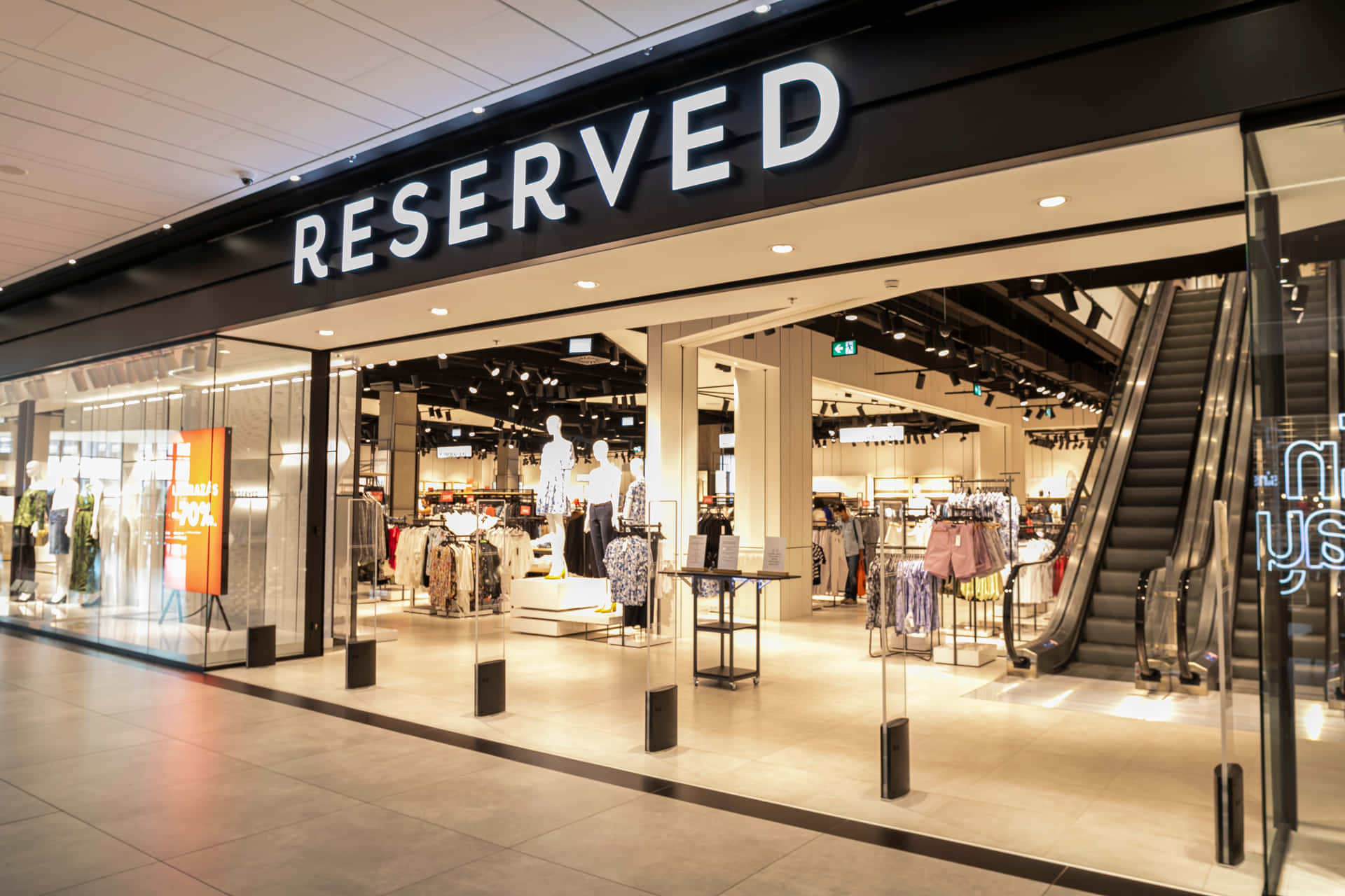 Reserved服裝店入口，配有玻璃牆和自動扶梯。