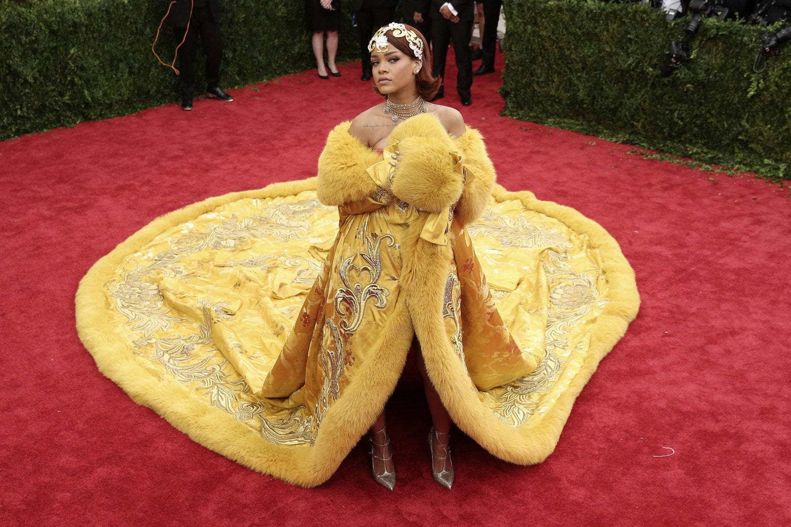 Rihanna 在活動的紅地毯上身穿金色毛皮邊飾長袍。