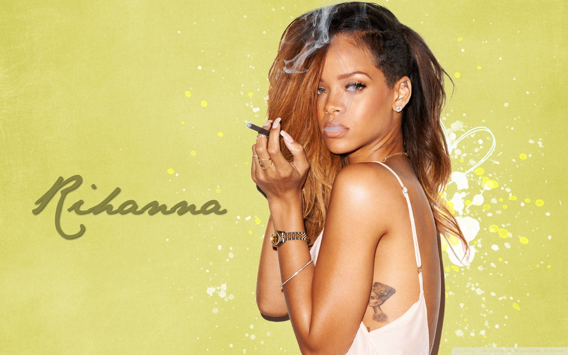 Rihanna 拿著一支煙，煙霧在帶有油漆飛濺的青檸綠色背景上升起。
