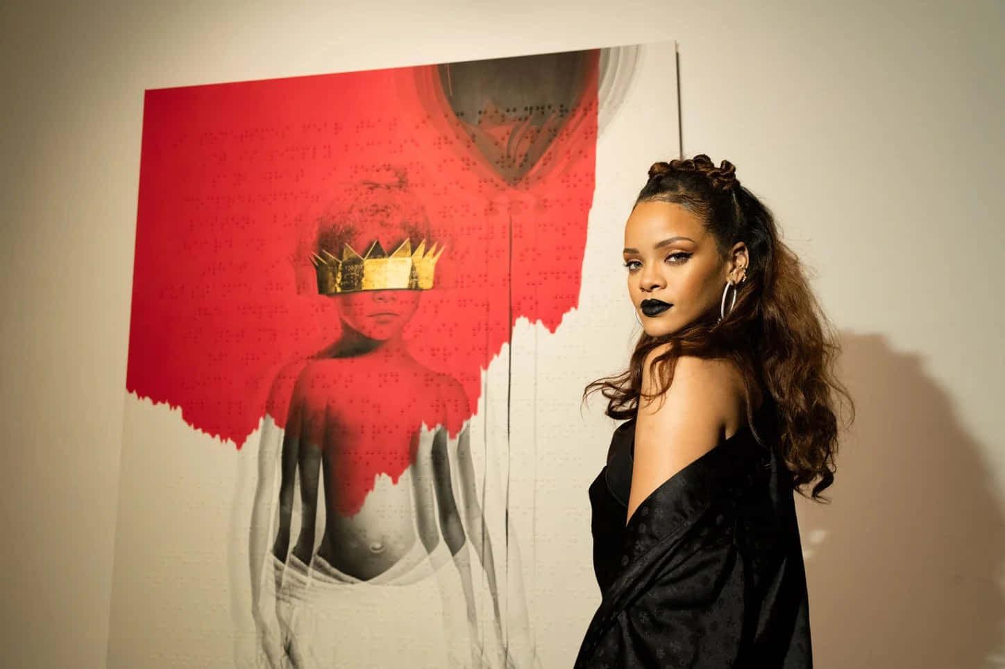 Black Culture 桌布 壁紙 — Rihanna 自信地擺姿勢，旁邊是一幅大膽的紅白藝術作品，描繪了一個戴著皇冠的人物，塗著戲劇性的黑色唇膏，頭髮飄逸。