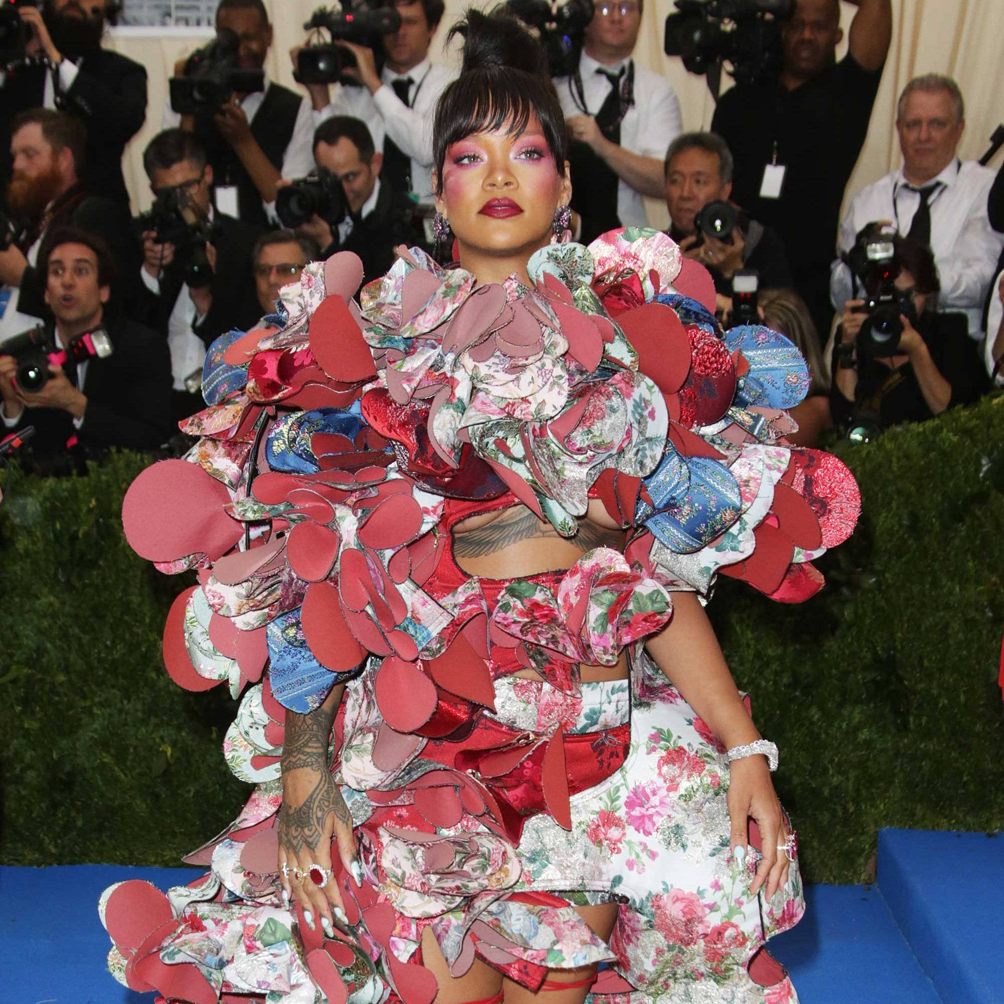 Rihanna 身穿 Comme Des Garçons 壁紙 — Rihanna 身穿大膽花卉禮服，飾有紅色圓形布料，在華麗的紅地毯活動中擺姿勢。