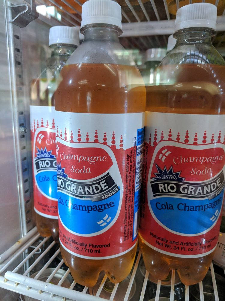 Rio Grande香檳汽水冰箱冷藏 壁紙 — 三瓶Rio Grande Cola Champagne汽水冷藏放在雪櫃內的鐵絲架上。