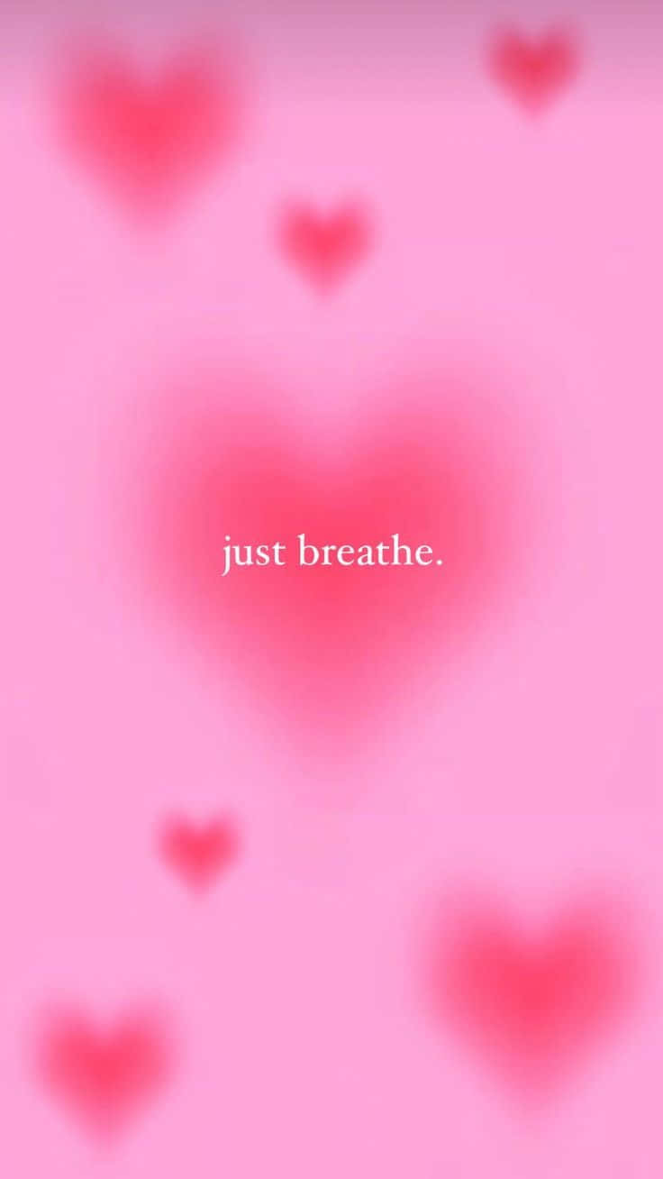 粉紅色背景，帶有模糊的心形圖案和文字 just breathe — 粉紅色心形動圖 壁紙