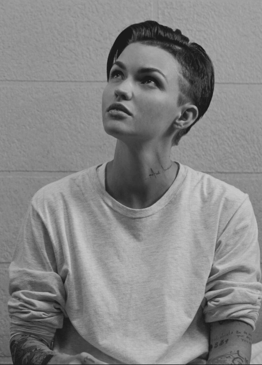 Ruby Rose 黑白照 壁紙 — 一個有紋身、短髮的人嘅黑白肖像，向上凝視住有紋理嘅牆壁。