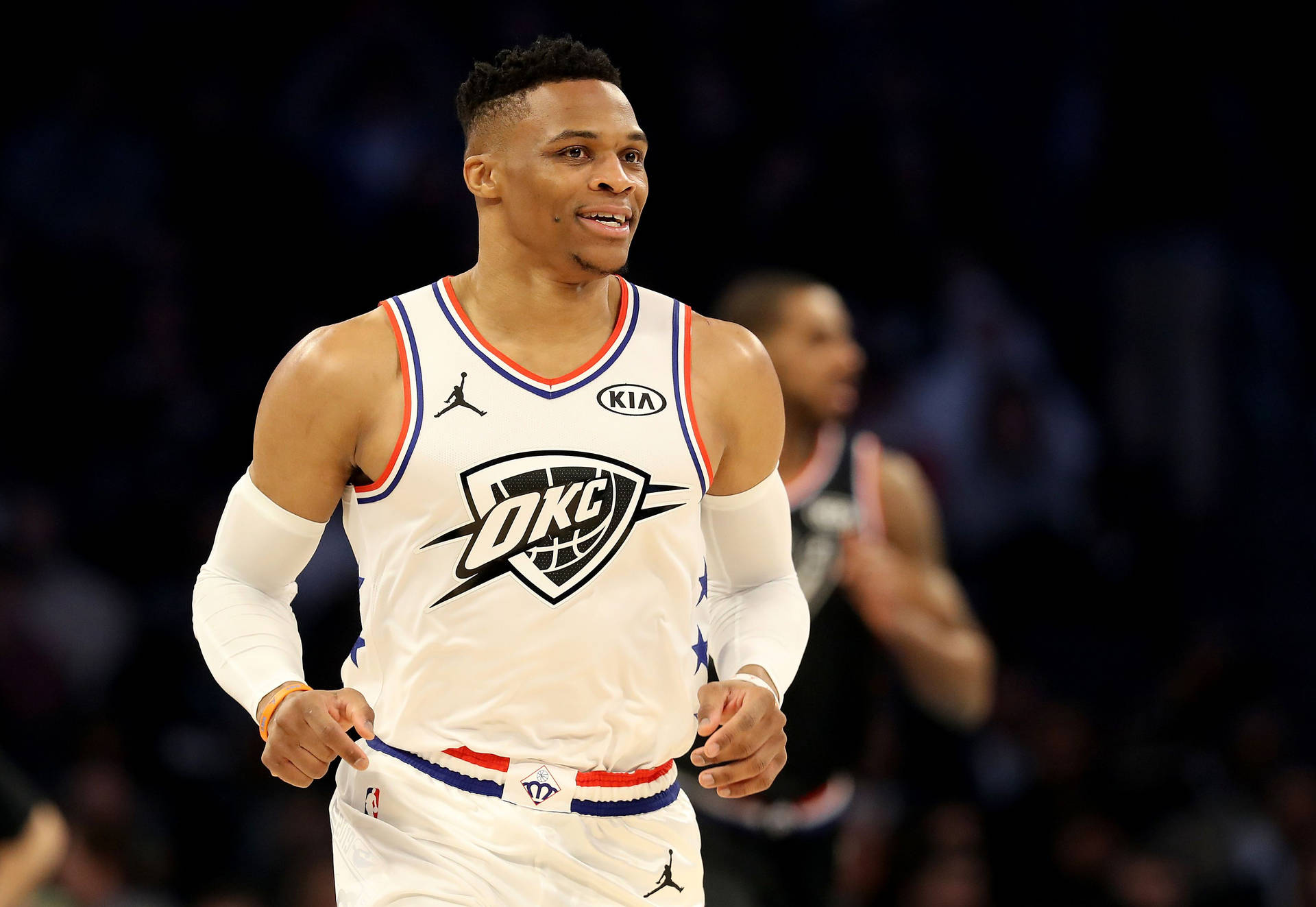 身穿白色OKC球衣的籃球運動員在比賽中在球場上奔跑。