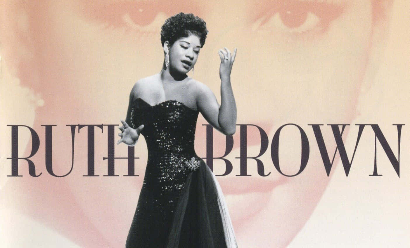  壁紙 — Ruth Brown 身穿閃亮黑色長裙，在柔和的粉紅色背景前以富有表現力的手勢表演，她的名字以粗體文字顯示。