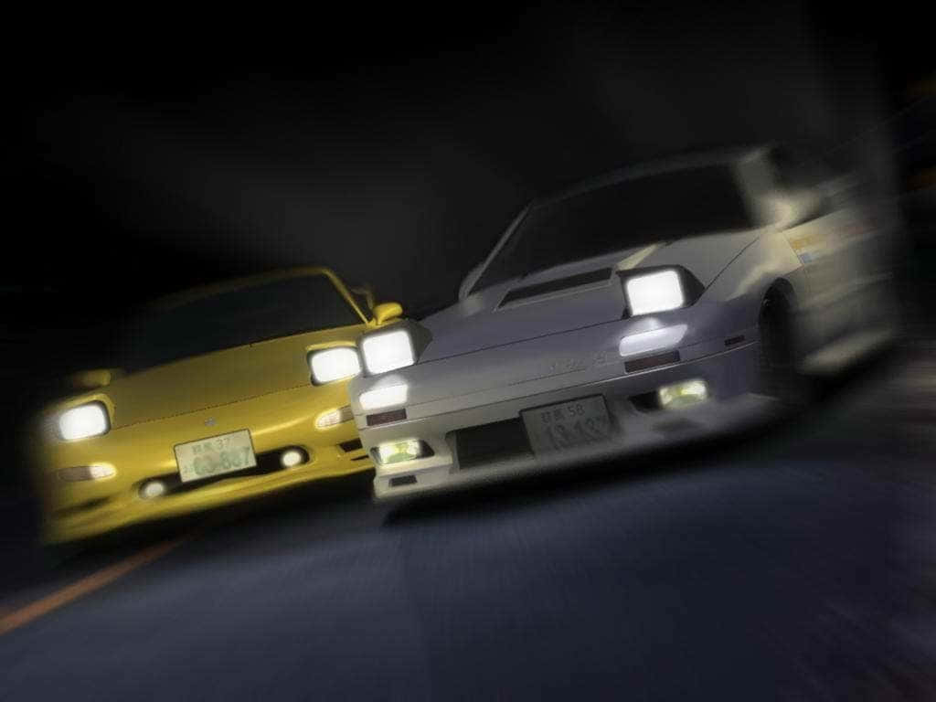 駕馭RX7 Fc，暢遊公路 壁紙 — 兩輛跑車在夜間比賽，車頭燈照亮黑暗模糊的道路。