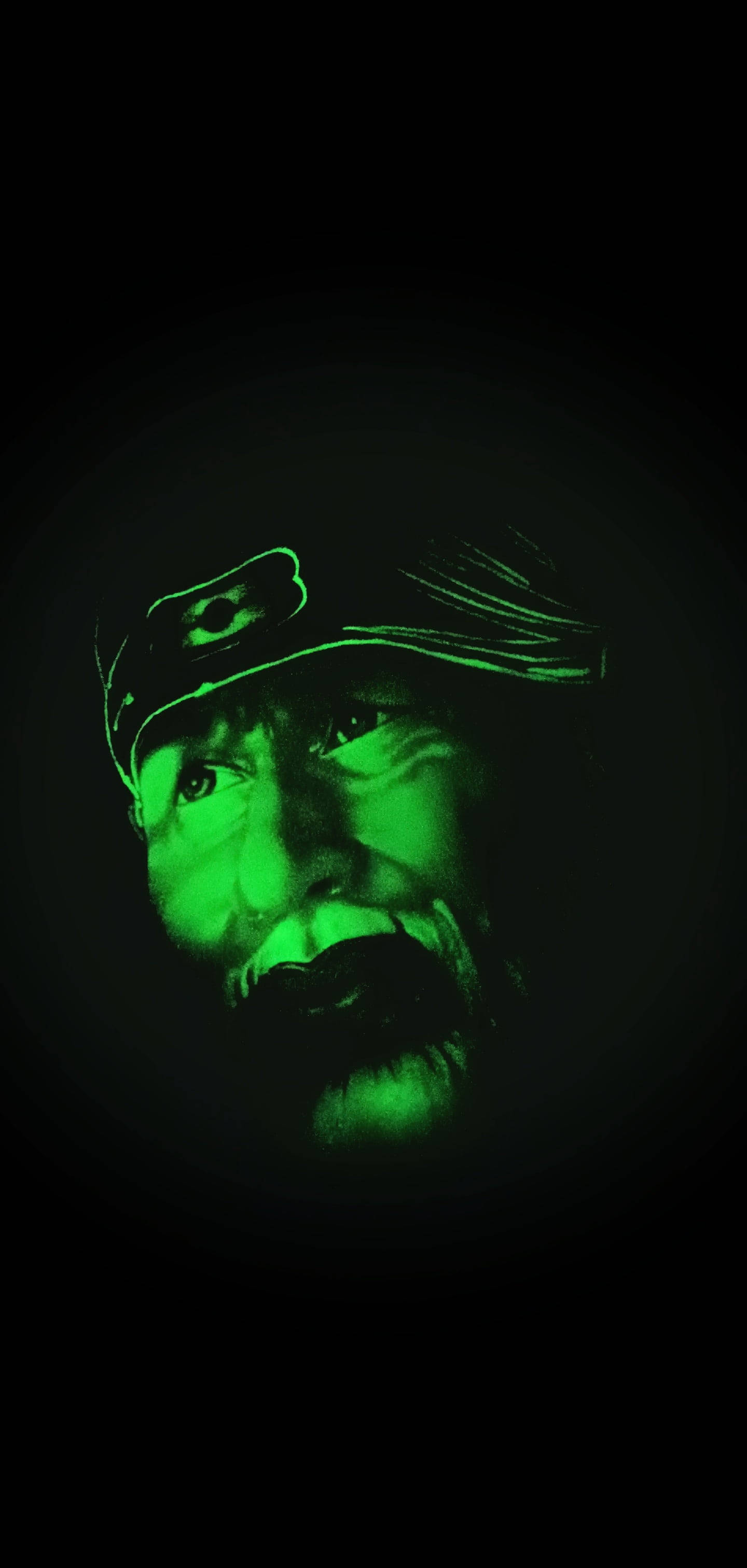 上師 Sai Baba 畫像手機壁紙 壁紙 — 一個男人強烈的臉在完全黑暗中發出綠光，由夜視效果照亮。