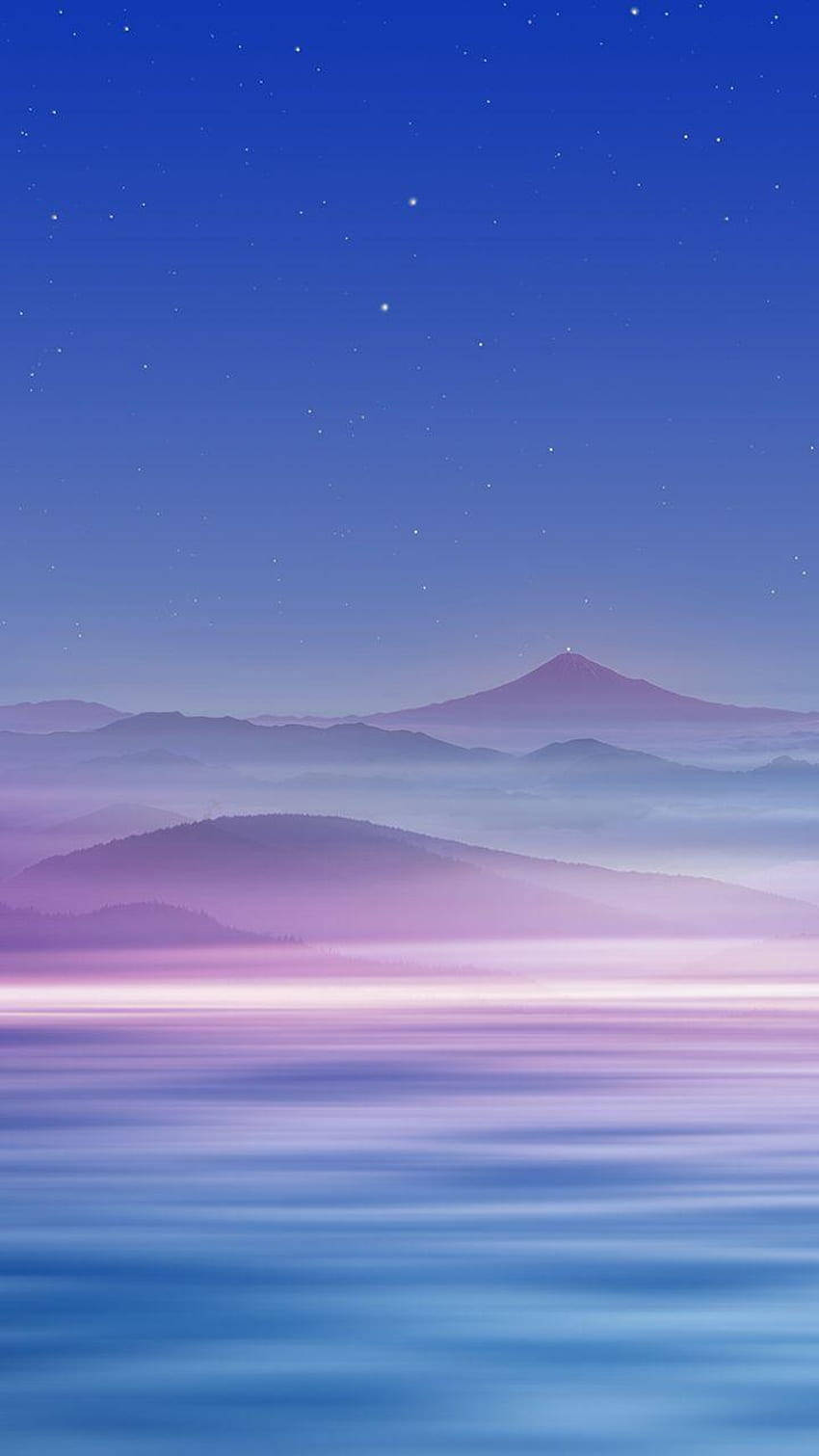 星空下霧氣繚繞的山脈倒映在平靜的水面