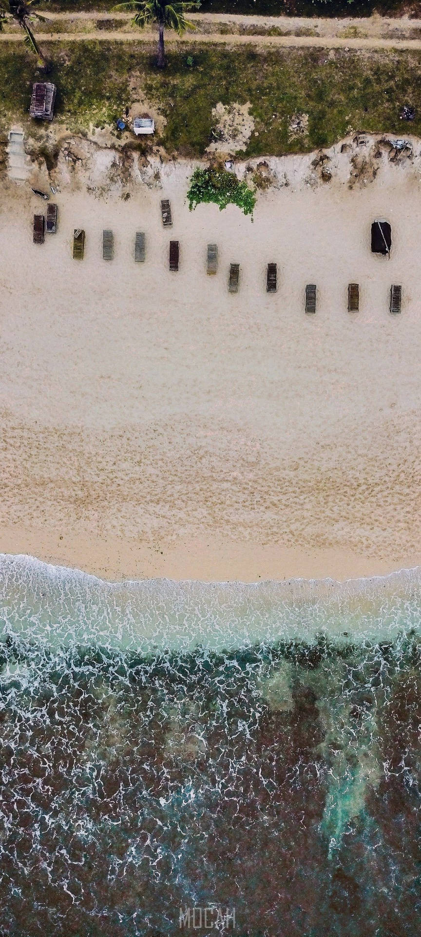 沙灘上的一排排沙灘躺椅，伴隨著碧綠的海浪。