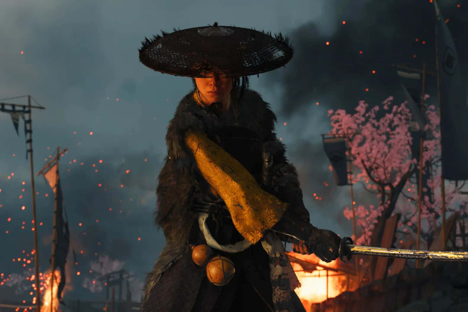  壁紙 — 一位戴著寬邊帽的武士戰士在充滿火焰和煙霧的戰場上堅定站立，背景中櫻花閃耀。