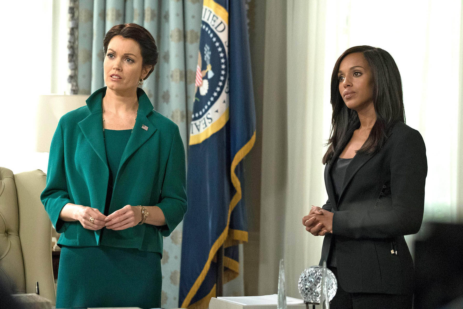 《Scandal》中的米莉·格蘭特與奧利維亞·波普 壁紙 — 兩位穿著專業服裝的女性站在辦公室裡，身後有一面美國國旗。