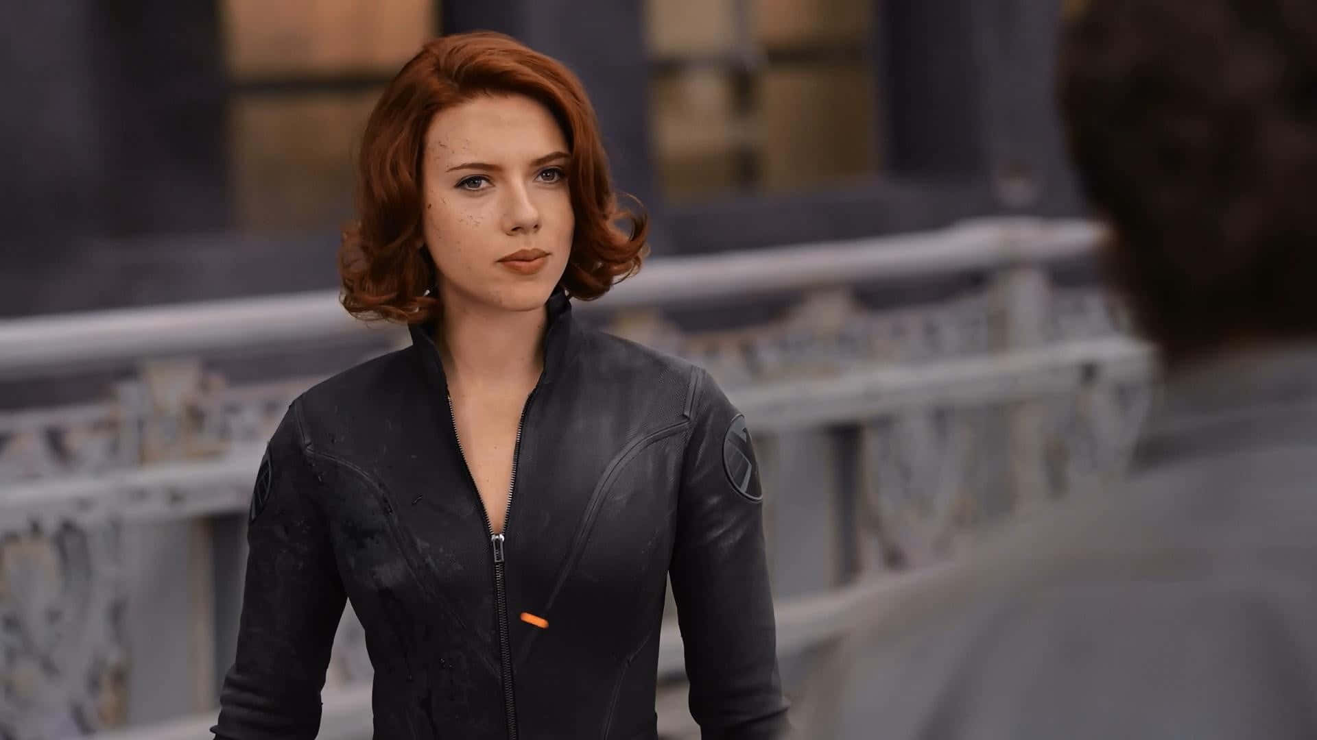 黑寡婦 桌布 壁紙 — Scarlet Witch 身處 gritty 城市環境，身穿黑色戰術外套，配有橙色拉鍊細節。