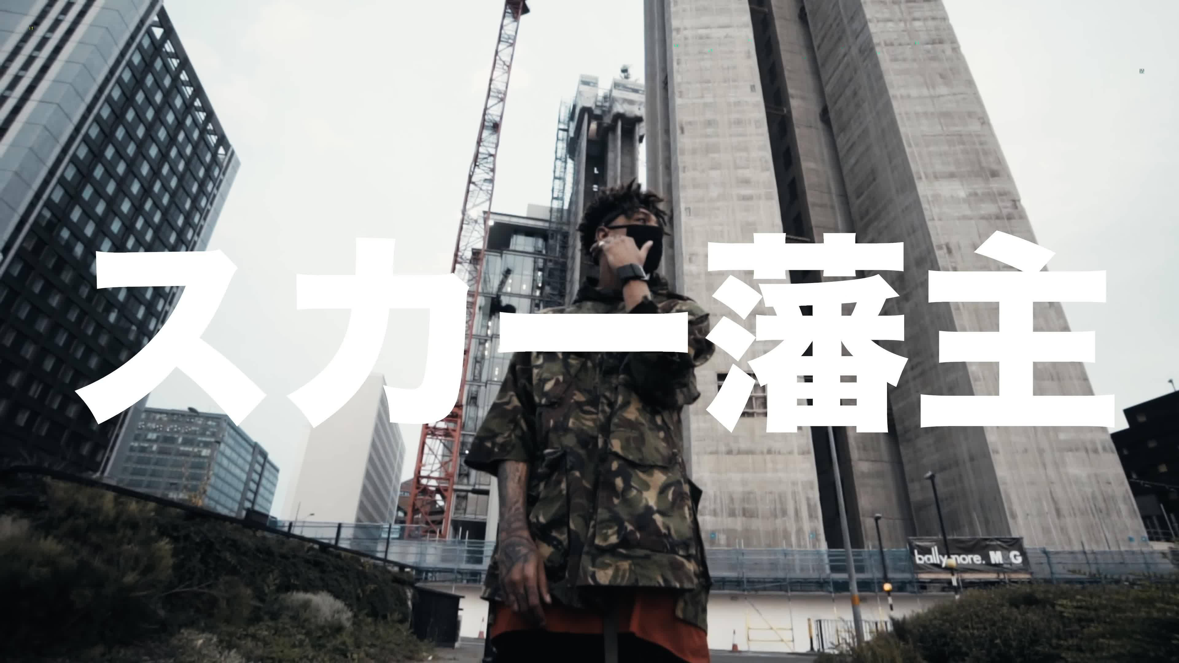 Scarlxrd 在倫敦 壁紙 — 一個穿著迷彩外套的人站在一個灰塵滿佈的城市建築工地，周圍是高聳的建築物和起重機，天空多雲。